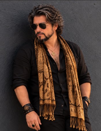 Composição masculina com camisa preta, lenço dourado e acessórios de couro